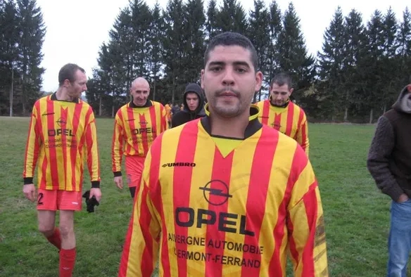 Joueur de foot en rouge et jaune qui pose fièrement