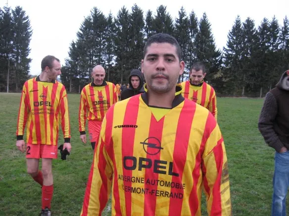 Joueur de foot en rouge et jaune qui pose fièrement