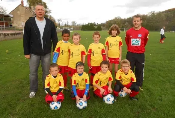 Jeunes joueurs de foot, posant sur la pelouse du stade