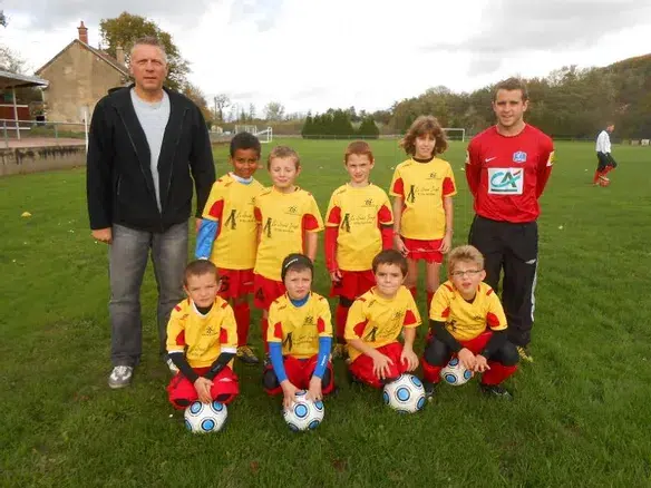 Jeunes joueurs de foot, posant sur la pelouse du stade