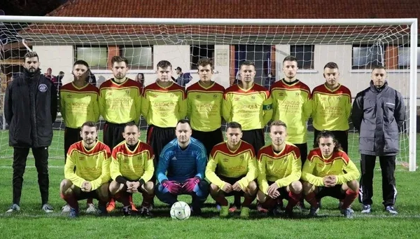 Joueurs de foot en jaune et rouge, posant fièrement devant les cages