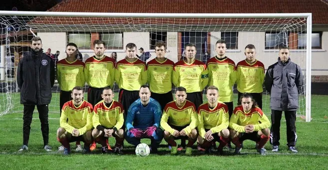 Joueurs de foot en jaune et rouge, posant fièrement devant les cages