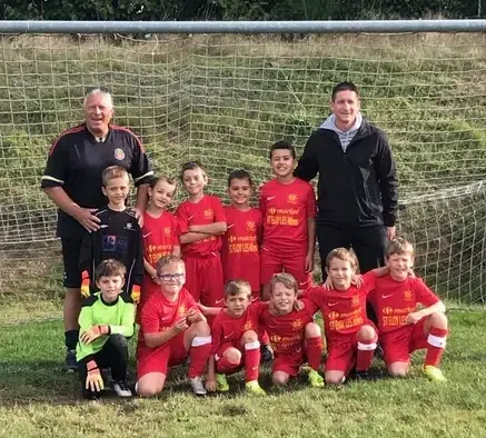 joueurs de foot très jeunes, posant devant les cages