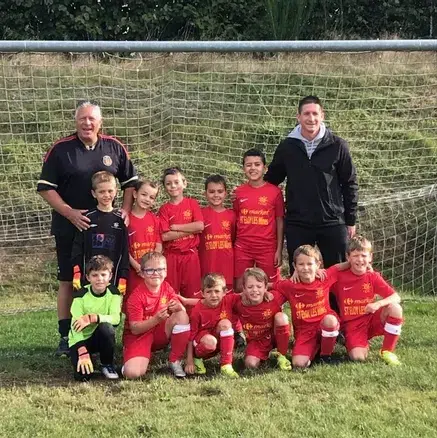 joueurs de foot très jeunes, posant devant les cages