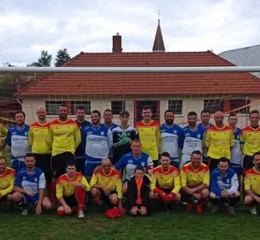 Equipe de foot, en maillot jaune et rouge posant devant les cages