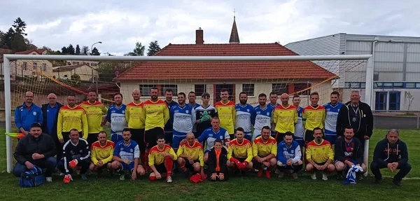 Equipe de foot, en maillot jaune et rouge posant devant les cages